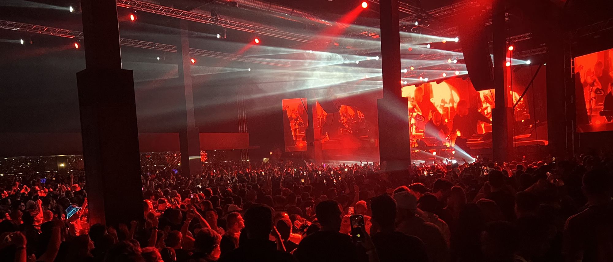 A festival crowd under red stage lights